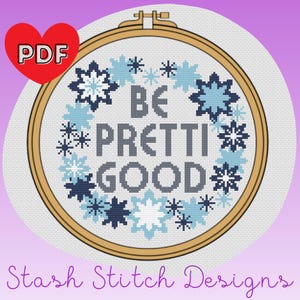 May include: A cross-stitch design in a wooden embroidery hoop. The design features the words "BE PRETTI GOOD" in gray, surrounded by blue and white snowflake-like patterns. A red heart with "PDF" is in the upper left. The text "Stash Stitch Designs" is at the bottom.