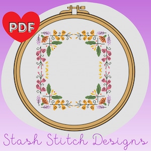 May include: A cross stitch pattern featuring a floral border in shades of pink, orange, yellow, and green. The pattern is displayed in a wooden embroidery hoop. The text "PDF" is visible in a red heart shape.