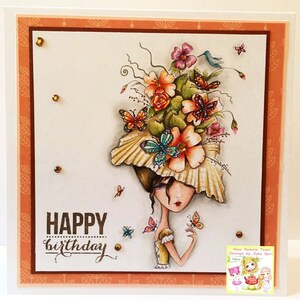 May include: A colorful birthday card with a whimsical illustration of a woman with a flower-adorned hat and butterflies. The card reads "Happy birthday".