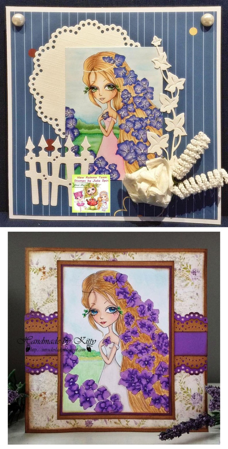 May include: A handmade card featuring a purple flower girl with long blonde hair. The card is decorated with a white picket fence, a white flower, and a white lace doily. The card is signed "Handmade by Kitty" and includes a website address.