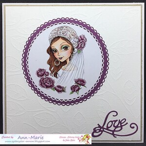 May include: A purple and white card with a circle in the centre. The circle contains a drawing of a woman with brown hair wearing a white veil and a lace hat. The woman is surrounded by pink flowers. The word "Love" is written in purple script in the bottom right corner of the card.