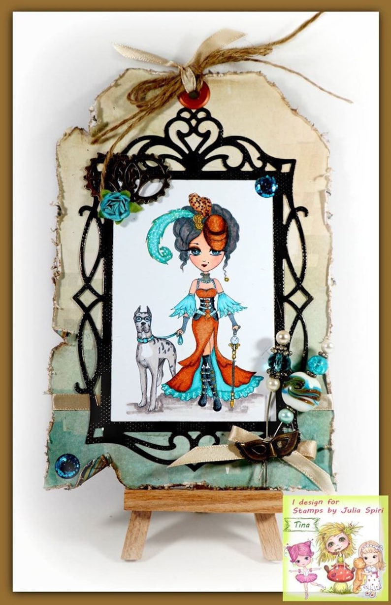 May include: A whimsical illustration of a woman in a steampunk-inspired outfit with a feathered hat and a dog. The illustration is framed in black and set on a wooden easel. The text "I design for Stamps by Julia Spirit Tina" is visible in the lower right corner.