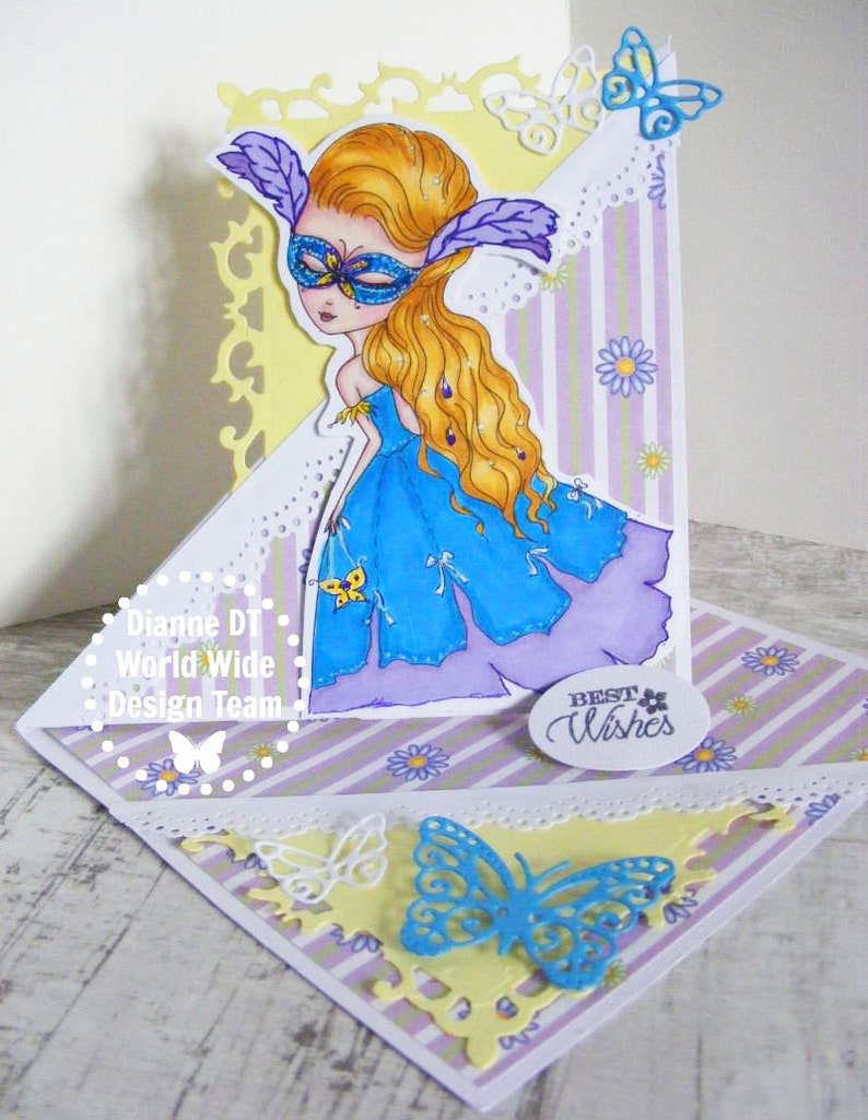May include: A handmade card with a purple, blue, and yellow color scheme. The card features a masked girl with long blonde hair, butterflies, and the text "Best Wishes".