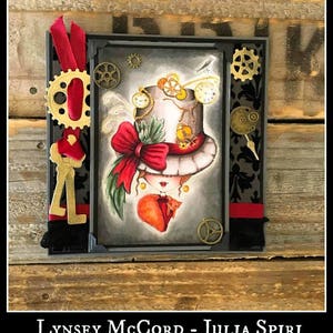 May include: A handmade card with a steampunk theme featuring a girl with a top hat, a red bow, and a cat. The card is decorated with gears, keys, and other embellishments.