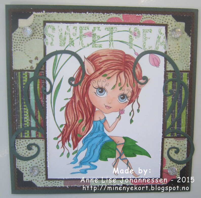 May include: A handmade card featuring a whimsical illustration of a fairy with red hair and blue eyes. The fairy is holding a pink flower and is surrounded by green leaves. The card is decorated with a green and brown patterned paper and the words "Sweet Pea" are written in white letters. The card also includes the text "Made by: Anne Lise Johannessen - 2015 http://minenyekort.blogspot.no"