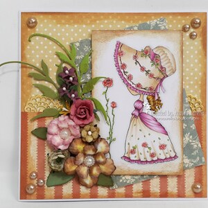 May include: A handmade card with a vintage-style illustration of a girl wearing a hat with roses. The card features a variety of paper textures and embellishments, including flowers, leaves, and lace. The card is decorated with a variety of colors, including pink, green, brown, and white. The card is signed "Created by Aurora Aurelia".