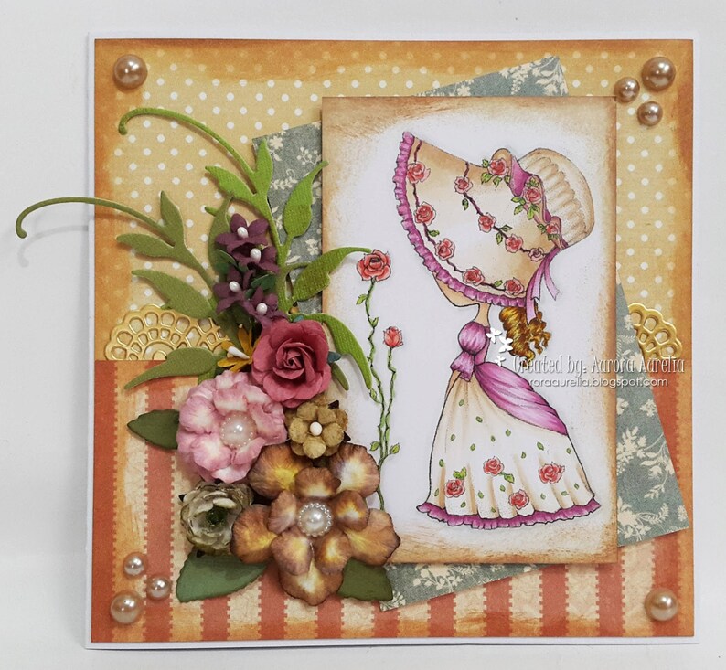 May include: A handmade card with a vintage-style illustration of a girl wearing a hat with roses. The card features a variety of paper textures and embellishments, including flowers, leaves, and lace. The card is decorated with a variety of colors, including pink, green, brown, and white. The card is signed "Created by Aurora Aurelia".