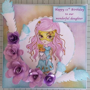 May include: A handmade card with a purple, pink, and blue color scheme. The card features a girl with pink hair wearing a yellow mask and holding a cat. The card has the text "Happy 11th Birthday to our wonderful daughter".