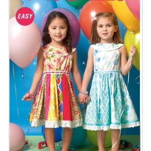 May include: Two girls wearing colorful dresses stand in front of a blue background with balloons. The girl on the left is wearing a multi-colored dress with a floral print and a white lace trim. The girl on the right is wearing a light blue dress with a white trim and a white collar. The text "EASY" is in a red circle on the left side of the image. The text "McCALL'S" is in red at the top of the image.