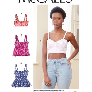 May include: McCall's sewing pattern for Misses' tops. The image shows illustrations of four different top designs, including a pink gingham crop top. The model is wearing a pink and white gingham crop top and light blue jeans. The pattern number is M7958.