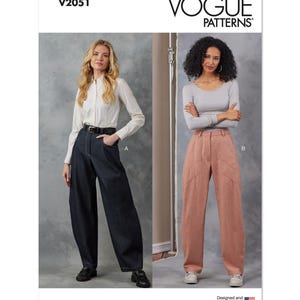May include: Vogue Patterns V2051 sewing pattern for wide-leg pants. Two models are shown wearing the pants in different fabrics. One model is wearing a white shirt and dark blue denim pants. The other model is wearing a grey long-sleeved shirt and pink pants. The pattern is designed and printed in the USA.