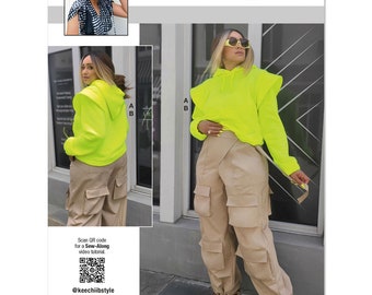 May include: A sewing pattern for a neon green hoodie with a ruffle detail on the shoulders and matching beige cargo pants. The pattern is called "knowME" by mimig and is designed and printed in the USA. The pattern includes a QR code for a sew-along video tutorial.
