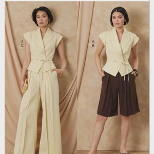 May include: Vogue Patterns fashion sewing pattern. The image shows two women wearing different outfits. One outfit is a light yellow blazer with matching wide-leg pants. The other outfit is a light yellow blazer with brown shorts. The Vogue Patterns logo is at the top.