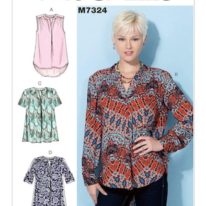 May include: McCall's sewing pattern M7324 for a women's blouse with four different style variations. The pattern includes a sleeveless blouse, a short-sleeved blouse, a long-sleeved blouse, and a tunic-length blouse. The model is wearing the long-sleeved blouse with a colorful geometric print.