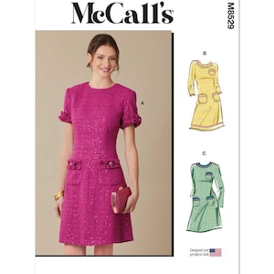 May include: McCall's sewing pattern for a dress with three different styles. The dress is shown in pink, yellow, and green. The pattern number is M8529.