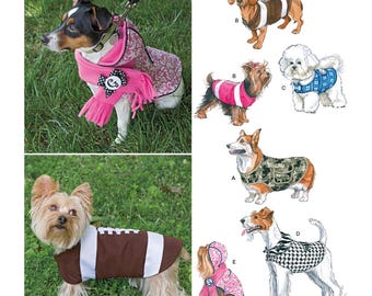 May include: A Simplicity sewing pattern for dog clothes, pattern number 1239. The pattern includes five different designs for dog clothes, including a football jersey, a scarf and vest, a camouflage vest, a houndstooth vest, and a pink hooded vest.
