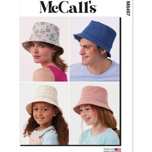 May include: A sewing pattern for four bucket hats. The pattern includes a floral print hat, a denim hat, a plaid hat, and a solid pink hat. The pattern is from McCall's and the pattern number is M8497. The pattern is designed and printed in the USA.