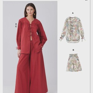May include: McCall's sewing pattern featuring a red long-sleeve top and wide-leg pants ensemble. The pattern also includes a floral print blouse and shorts. The text "McCall's" is at the top, with "M8663" on the right.