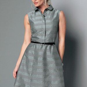 May include: Sleeveless gray dress with a collared neckline and a black belt. The dress has a subtle striped pattern and a button-down front. The skirt flares out from the waist.