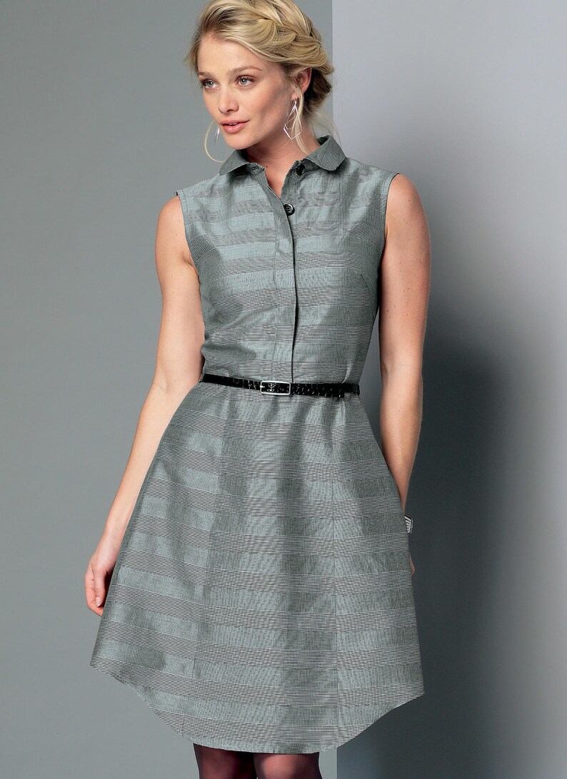 May include: Sleeveless gray dress with a collared neckline and a black belt. The dress has a subtle striped pattern and a button-down front. The skirt flares out from the waist.
