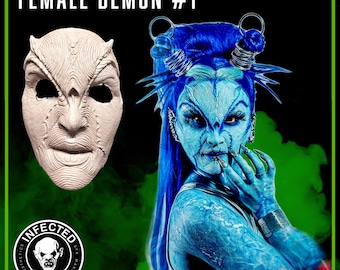 Peut inclure: Un gros plan d'un masque de démon féminin avec une surface texturée détaillée. Le masque est fait d'un matériau de couleur claire et a une apparence réaliste. Le masque est placé à côté d'une femme aux cheveux bleus et à la peinture corporelle, créant une scène dramatique et fantastique.