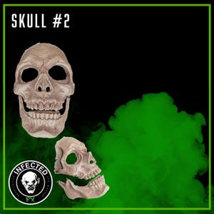 May include: Two beige skull masks against a black background with green smoke. The top mask is a full skull, while the bottom mask is a partial skull. The text "SKULL #2" is at the top, and a logo with the text "INFECTED FX" is at the bottom.