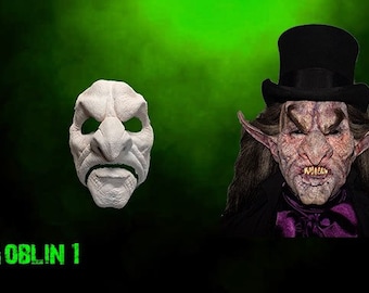 May include: A white goblin mask with a large nose and a scowling expression. The mask is next to a photo of a goblin wearing a top hat and a dark suit.
