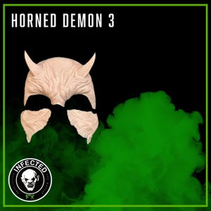 May include: A latex mask with the text "HORNED DEMON 3" at the top. The mask is a pale flesh color with two horns and black eye openings. The bottom left corner has a logo that says "INFECTED FX SFX MAKEUP". Green smoke fills the background.
