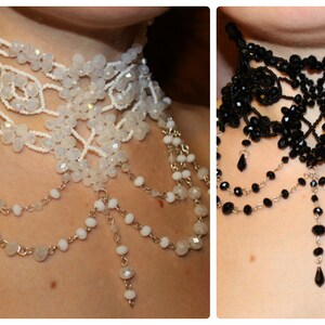 May include: Two beaded chokers, one white and one black, with dangling chains of beads. Both chokers have a delicate, intricate design.