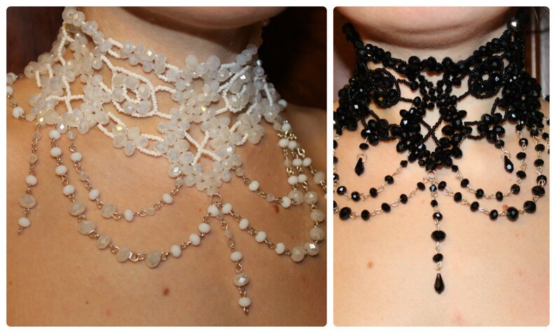 May include: Two beaded chokers, one white and one black, with dangling chains of beads. Both chokers have a delicate, intricate design.