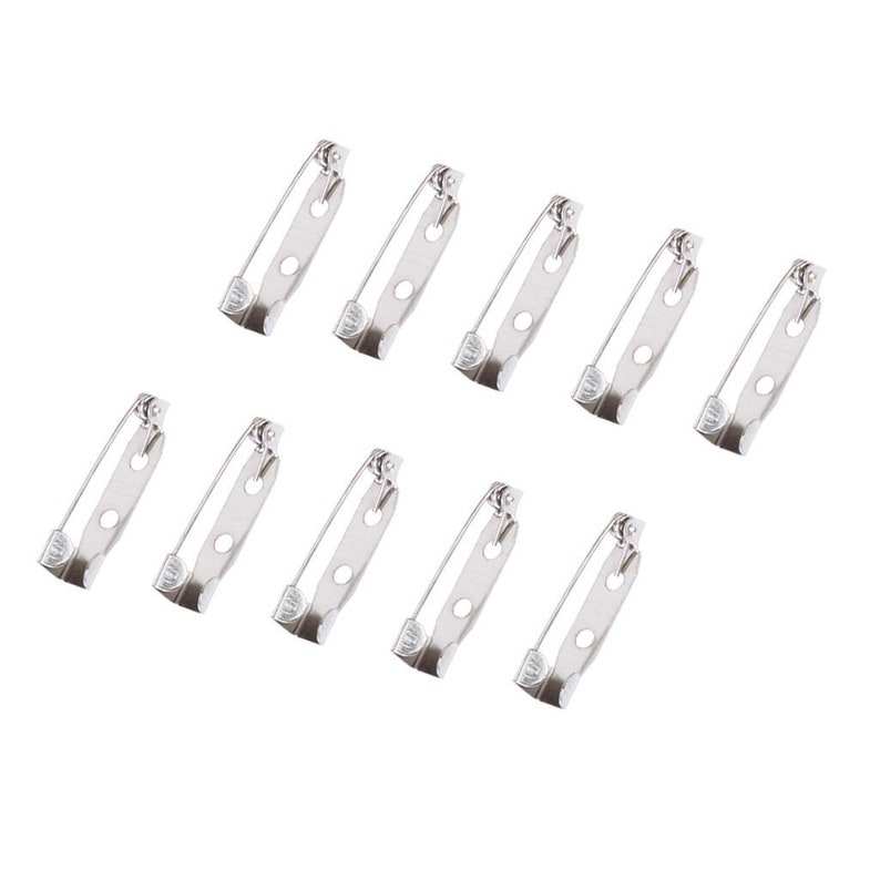 May include: Ten silver-toned safety pin closures. The pins are approximately 1 inch long and have a pointed end and a loop for attaching to fabric.