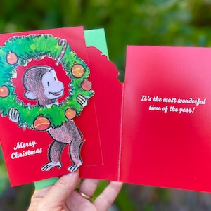 Curious George kerstkaart grappige kerstkaart in doos met aap en kerstkrans It's the Most Wonderful Time of the Year