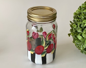 Hand painted mason jar (1 pint) with red roses. Great to use as a decorative piece or fill with your favorite goodies.