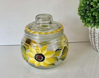 Candy or cookie jar with hand painted sunflowers all around with a sealed lid to keep everything fresh.