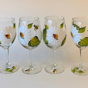 Painted wine glasses with daisies and bees. Listing is for one glass.