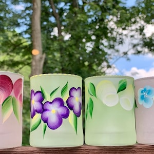 Hand painted candle holders on a frosted glass with various designs, choose one of your favorites. 2 3/4”tall x2”wide