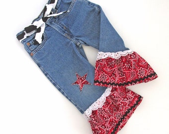 Girls 2T upcycled denim bell bottom jeans with red bandana ruffles, cowhide print tie belt & star patch on leg. Cute toddler cowgirl outfit.