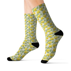 Könnte beinhalten: Ein Paar weiße Socken mit einem Zitronen- und Blattmotiv. Die Socken sind an Zehen und Ferse schwarz.