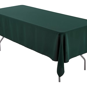 May include: A dark green rectangular tablecloth draped over a table with silver legs.