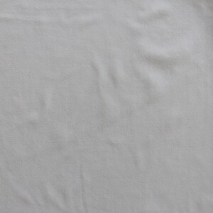 May include: A plain white fabric background with a smooth texture.