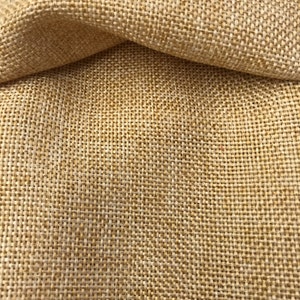 May include: Close-up of a beige burlap fabric with a woven texture.