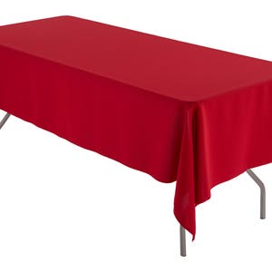 May include: A red rectangular tablecloth draped over a table with silver legs.