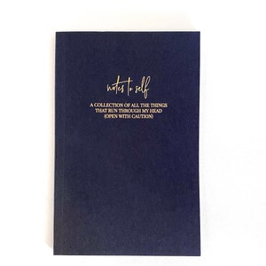 May include: A dark blue notebook with gold lettering that reads "notes to self" and "A collection of all the things that run through my head (open with caution)"