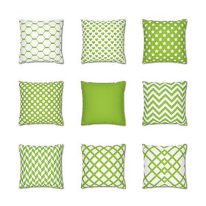 May include: Nine square throw pillows with various patterns. The patterns include white and green geometric shapes, hearts, stars, polka dots, chevrons, and a solid green pillow. The pillows are arranged in a three-by-three grid.