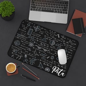 May include: Black mouse pad with white mathematical formulas and equations. The name "Pita" is written in white at the bottom of the mouse pad.