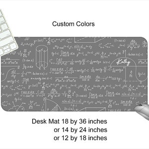 May include: A gray desk mat with white mathematical equations and formulas printed on it. The mat is available in three sizes: 18 by 36 inches, 14 by 24 inches, and 12 by 18 inches. The name "Kathy" is written on the mat.
