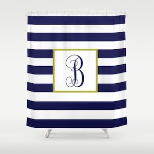 May include: Navy blue and white striped shower curtain with a gold frame and a navy blue monogram of the letter "B" in a script font.