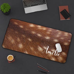 May include: A brown and white deer print mouse pad with the name "Amelie" printed in white on the bottom right corner.