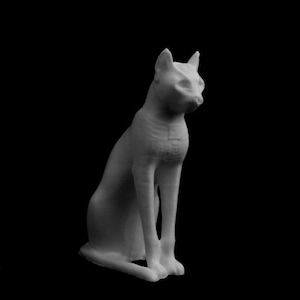 May include: A monochromatic sculpture of a seated cat with a sleek, stylized form. The cat is depicted in a seated position, with its front paws neatly aligned. The sculpture's surface has a textured appearance, and the cat's head is turned slightly to the side.