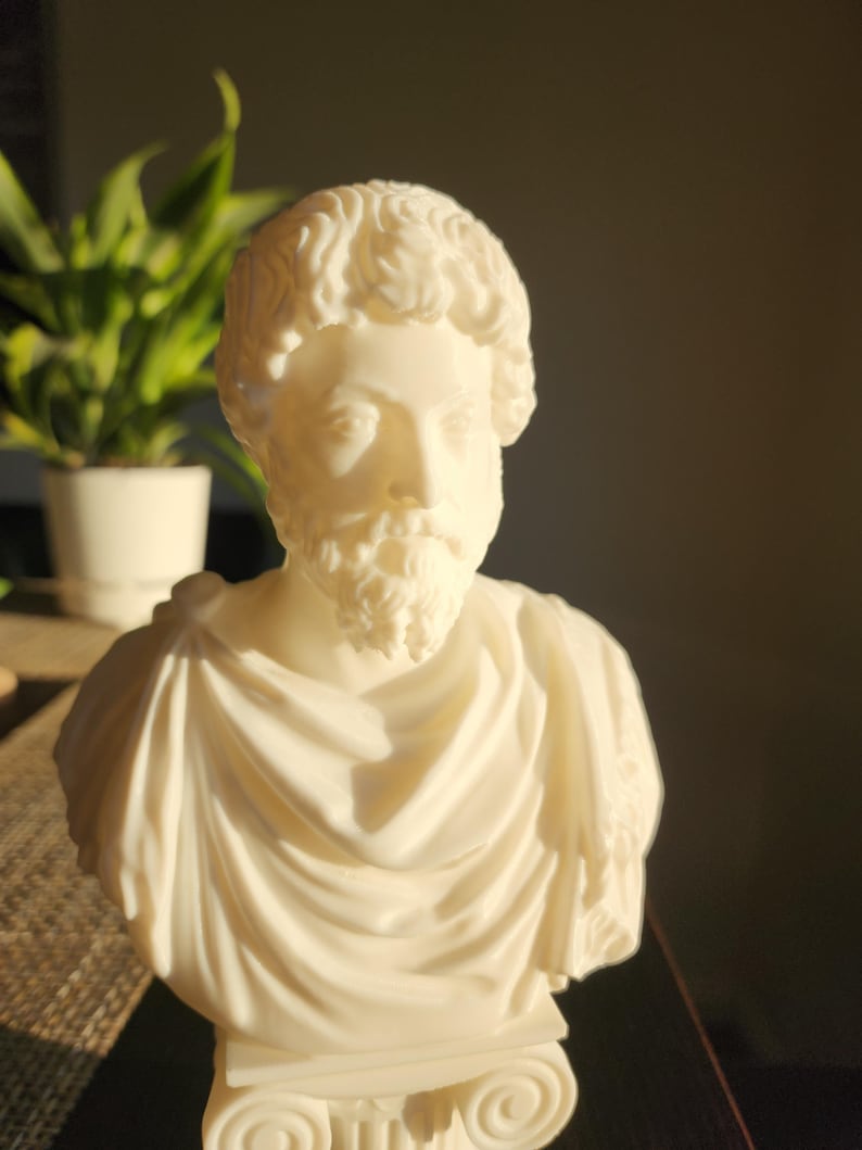 Puede incluir: Busto de yeso blanco de un hombre con barba y pelo corto. El busto est&aacute; sobre un pedestal redondo.
